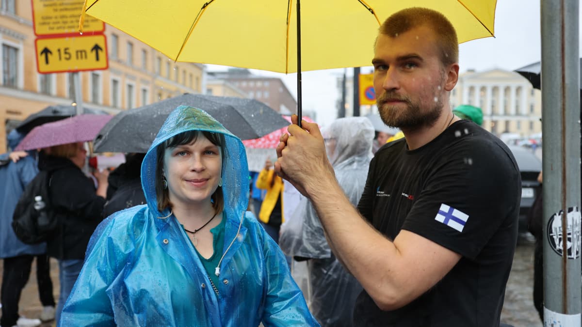 Nainen ja mies sateenvarjon alla. 
