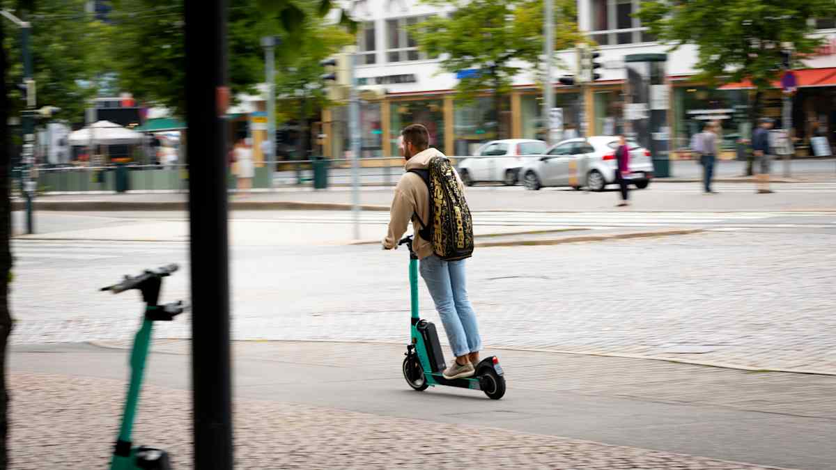 Mies ajaa sähköpotkulaudalla. 