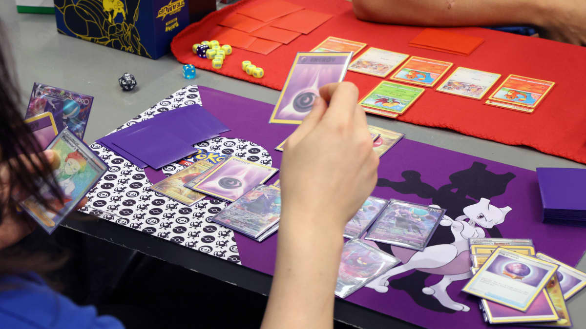 Pokémon-korttipelin pelaamista pöydän ääressä.