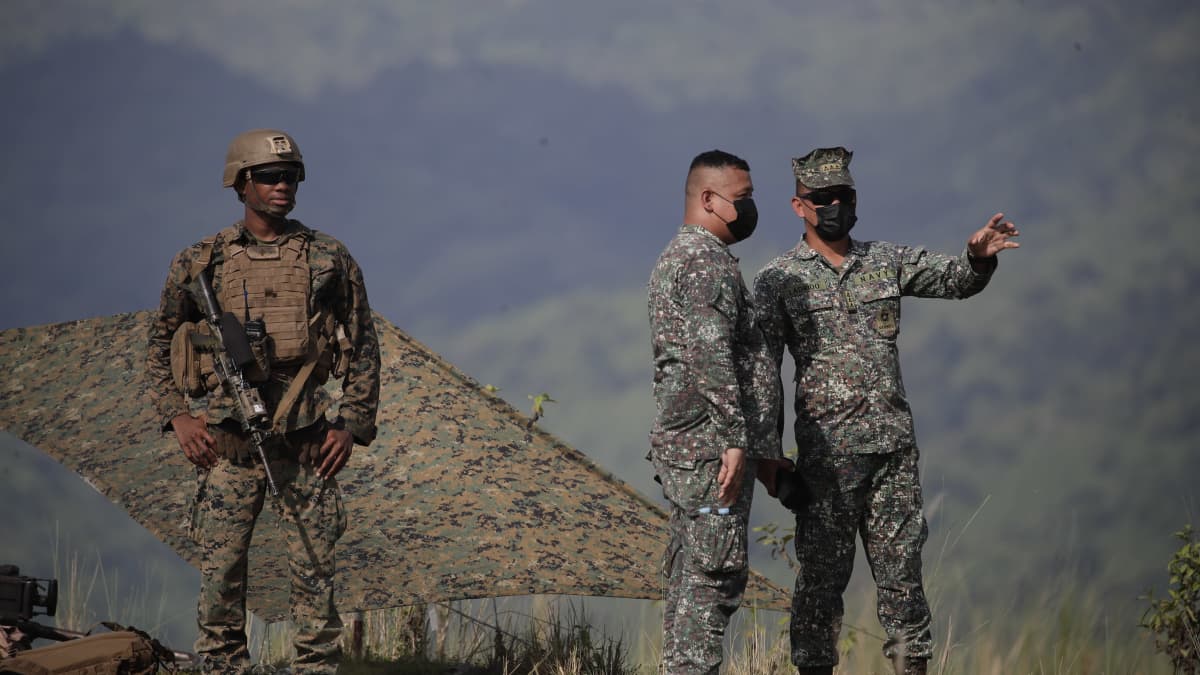 Yhdysvaltain sotilas (vas.) ja kaksi Filippiinien sotilasta (oik.) osallistuivat sotaharjoitukseen Tarlacin maakunnassa Filippiineillä 13. lokakuuta 2022. 