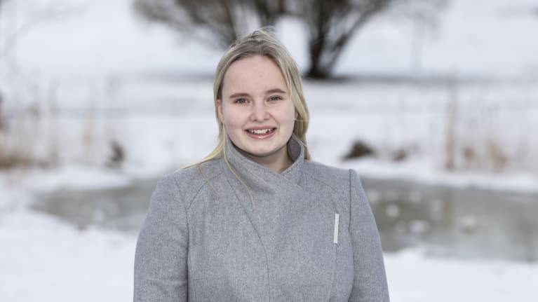 Aluevaaliehdokas Siru Nykänen hymyilee kameralle talvisessa maisemassa.