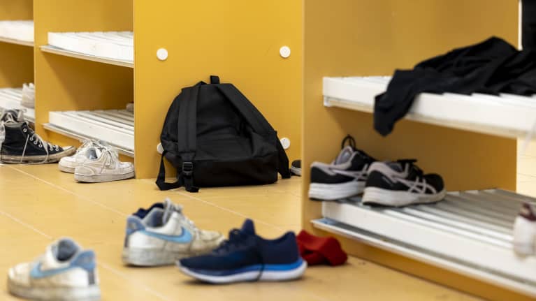 Reppuja ja kenkiä koulun naulakon edustalla.