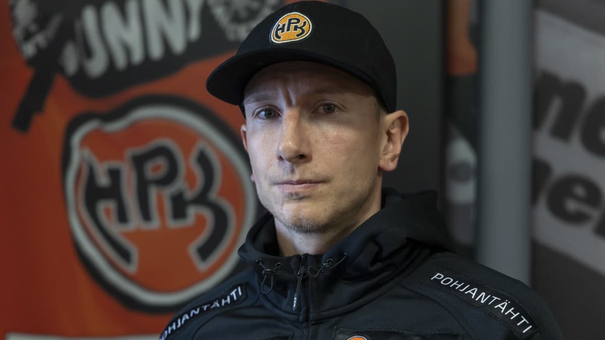 Juuso Hietanen seisoo HPK:n logon edessä. 