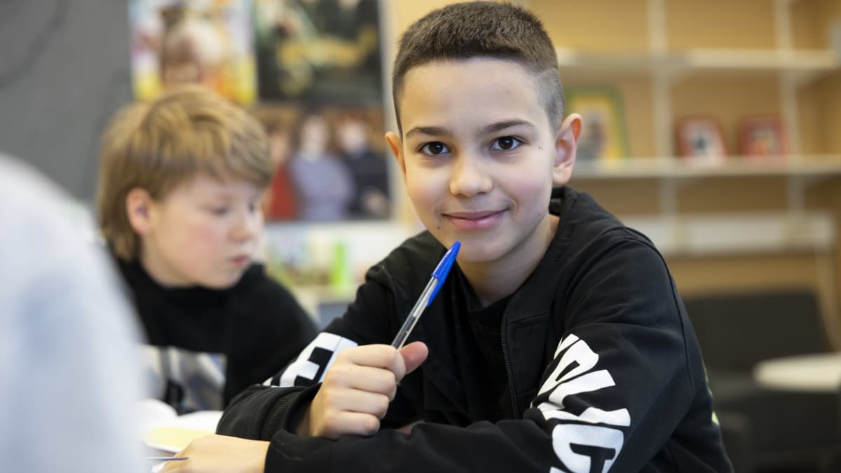 Ukranalainen poika katsoo kameraan koulussa.