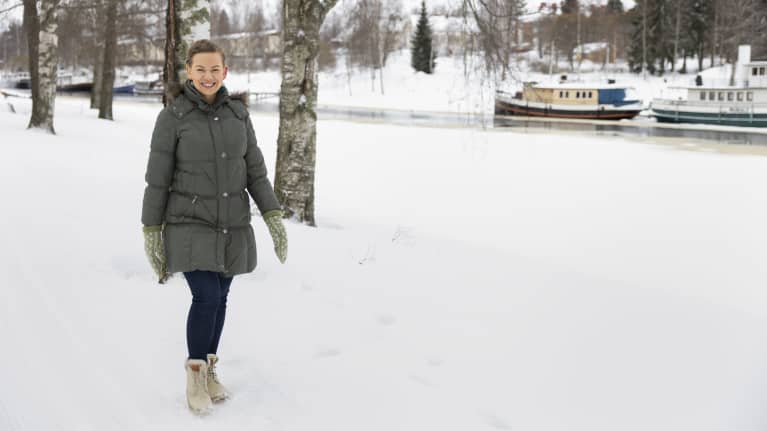 Kaie Hakola kävelee hiihtoladun vieressä Jämsänjoen rannalla.