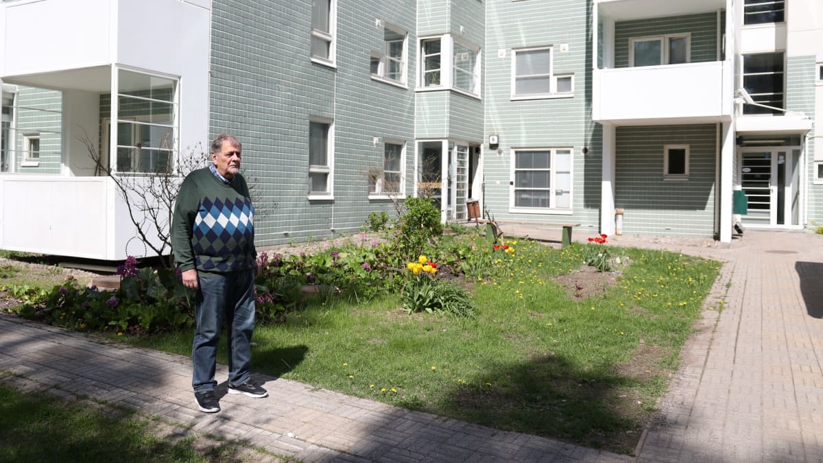 Hans Duncker katselee Heka-asuntonsa taloyhtiön pihapiiriä Helsingin Vuosaaressa. Kuvassa ruohikkoa ja taustalla kerrostaloasuntoja.