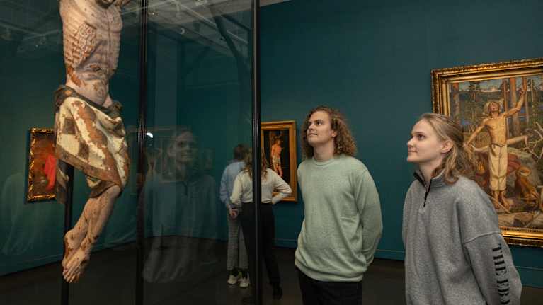 A young man and woman look at a sculpture.