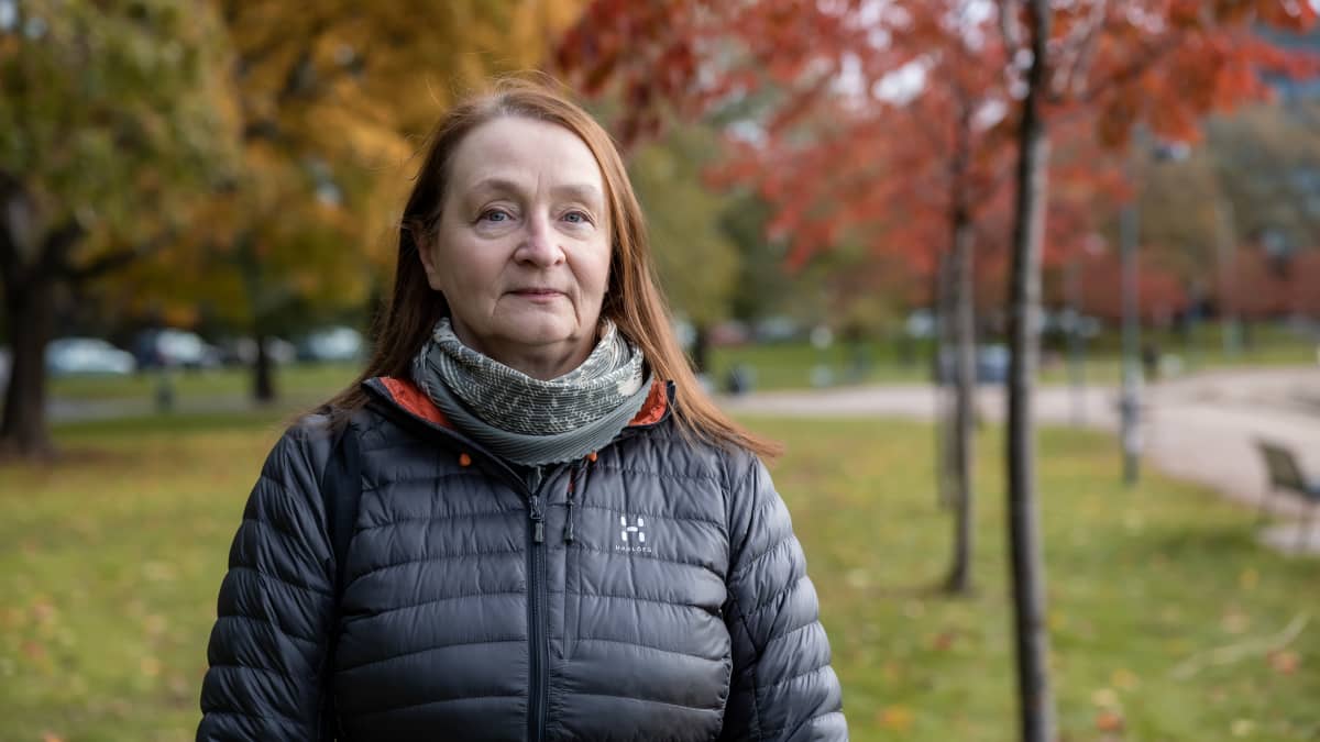 Tutkija Reija Ruuhela syksyisessä Tokoinrannassa taustalla vihertäviä ja punertavia puita.