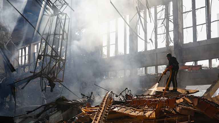 Ukrainian rescuers work at the site of a rocket strike.