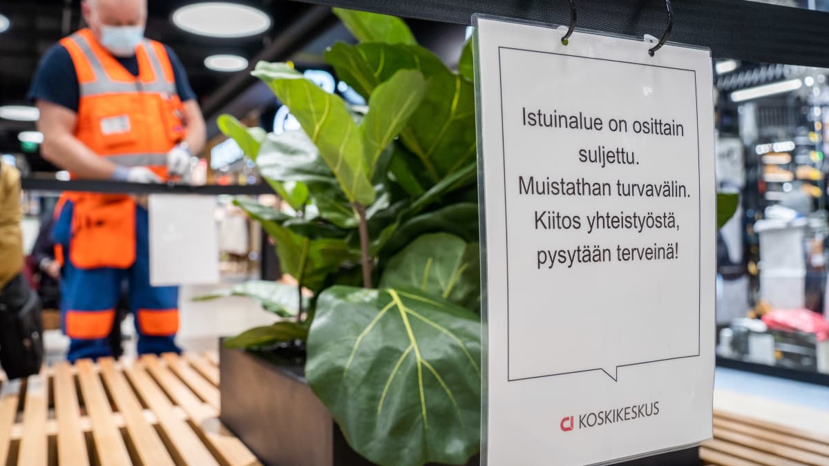 Työmiehiä asentamassa aitausta Koskikeskuksen yleisöpenkeille.