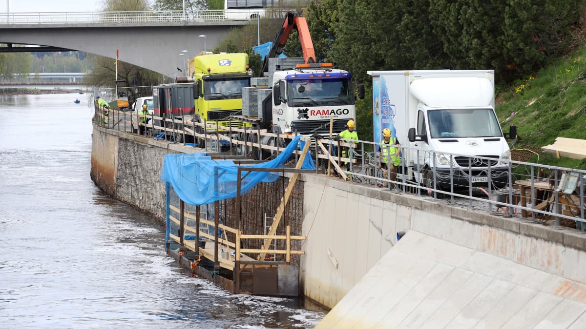 Nosturikuorma-auto pysäköitynä Oulujoen Merikosken voimalaitoksen alakanavan varteen, kanavan betoniseinässä on teräksisiä työmaarakenteita.