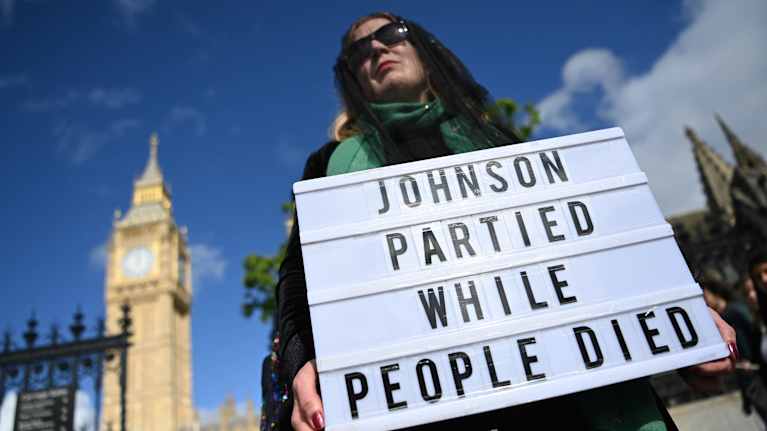 A protester's sign outside Parliament in London, UK says Boris Johnson is celebrating your man's death.