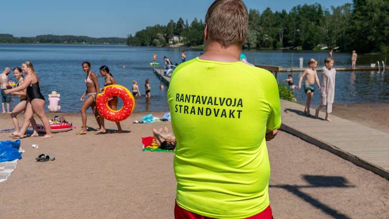 Rantavalvoja tarkkailee uimareita aurinkoisena kesäpäivänä.