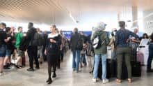 Ihmisiä jonossa turvatarkastukseen Helsinki-Vantaan lentokentällä 10.6.2022.