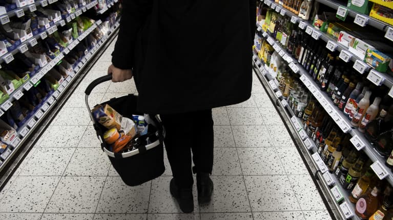 Asiakas kantaa ostoskoria ruokakaupassa.