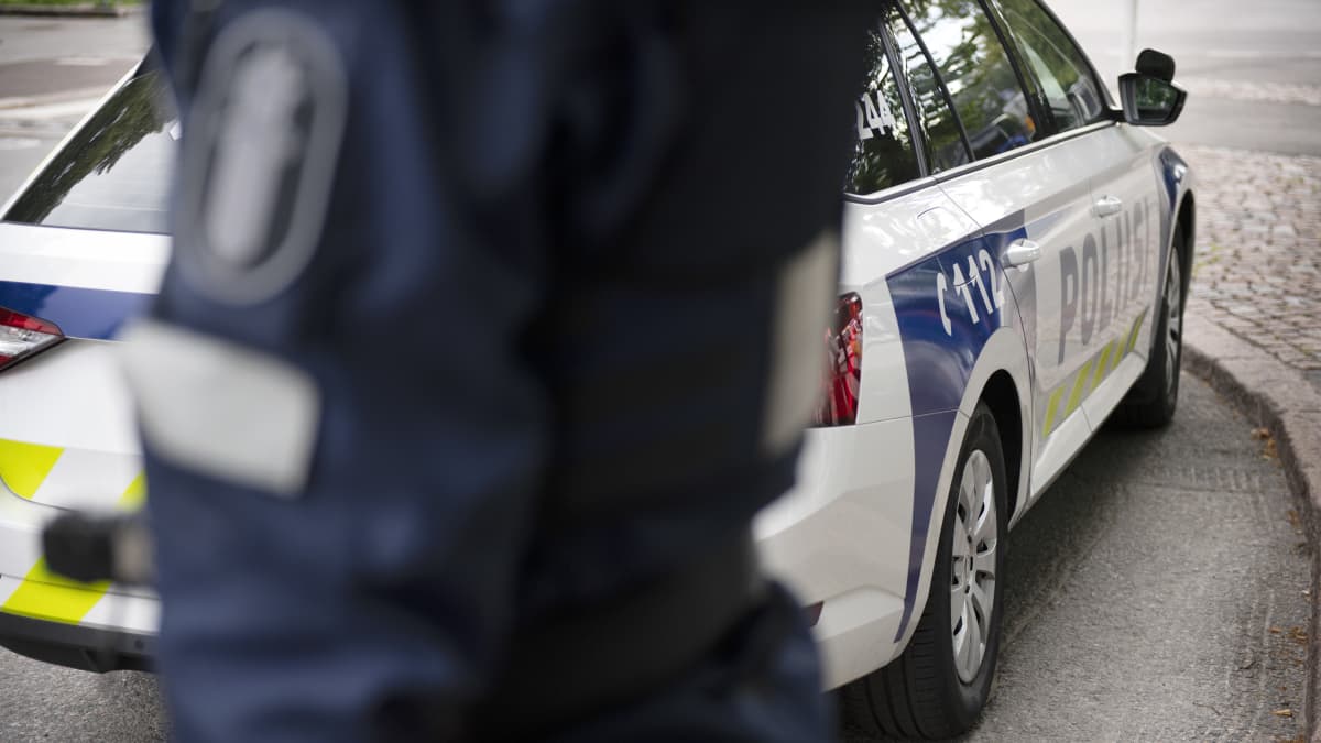 Poliisi ja poliisiauto.
