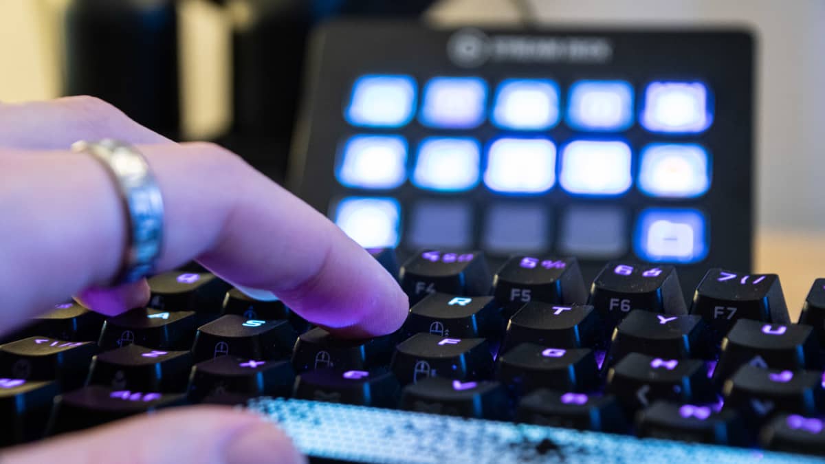 Närbild på fingrar som trycker på ett tangentbord som lyser.