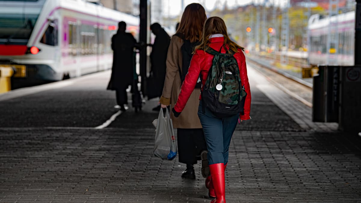Ihmisiä Helsingin rautatieasemalla menossa paikallisjuniin.