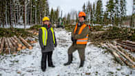 Saija Huuskonen och Markku Rantala står framför en skogsmaskin som håller på att avverka skog.