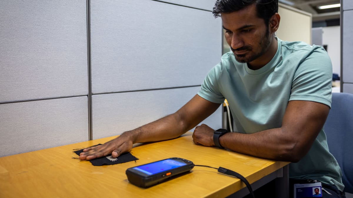 Shaikh Asif testaamassa kankaaseen kiinnitetyn lintukuvion avulla ohjattavaa mobiilipeliä.