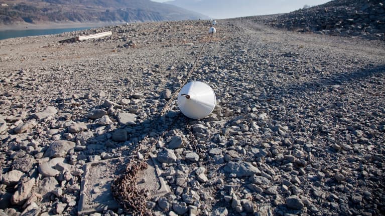 Järvenpohja on paljaana, metalliköydessä kuiville jääneitä poijuja.