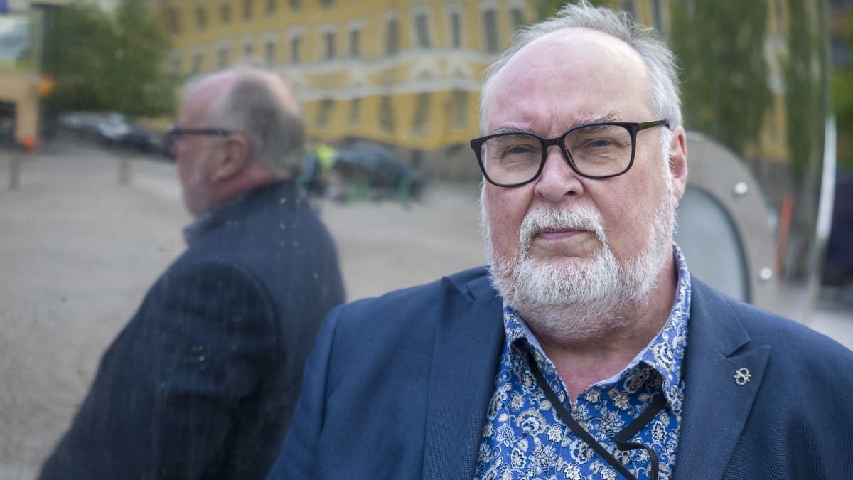  Jussi Karhilasta seisoo heijastavan pinnan edessä.