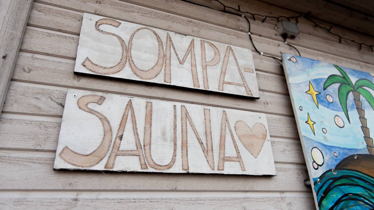 Sompasauna's sign and some of the artwork in frame.