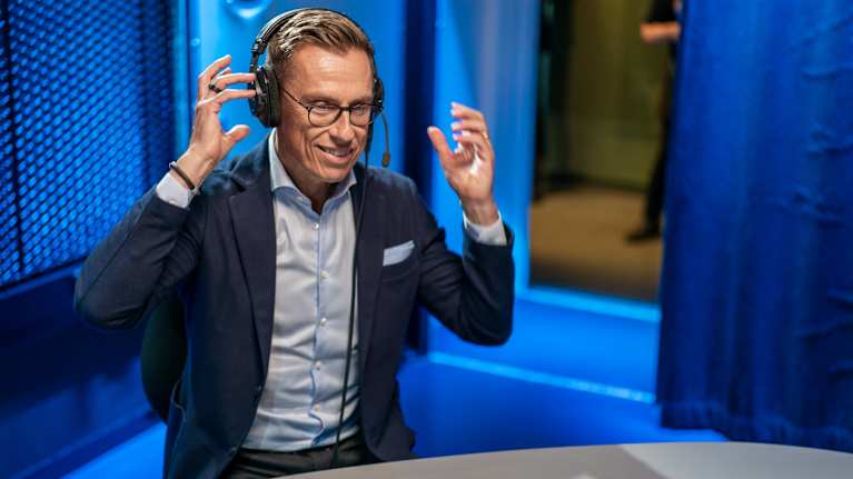 Alexander Stubb wears headphones in the radio studio. 