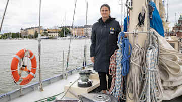 A woman is on the deck of a ship. 