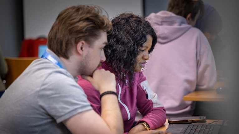 Nagny Iyamu tekee työhakemusta, Saku Kujala avustaa.