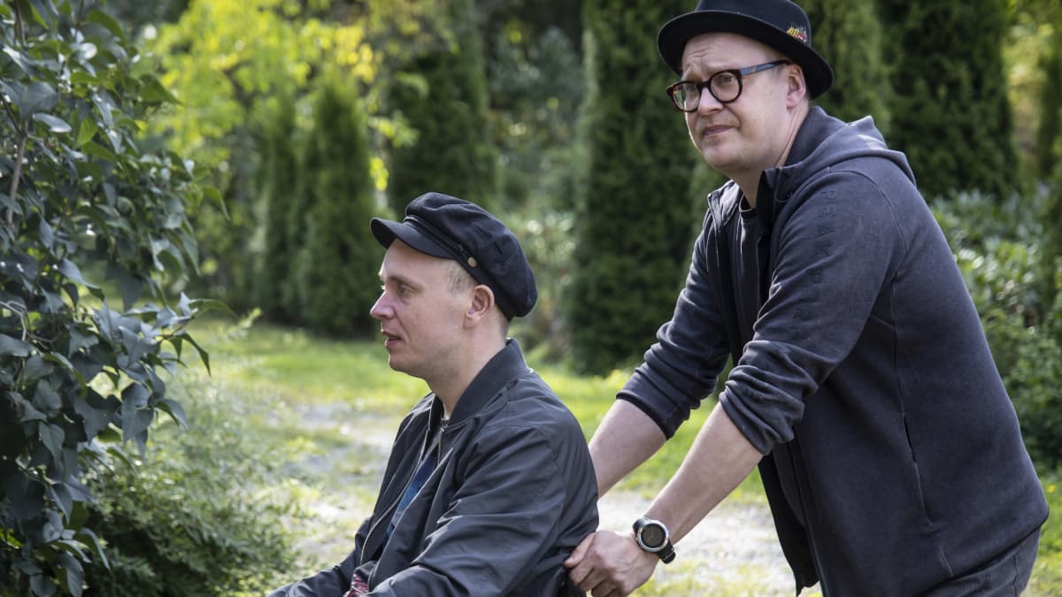 Teemu Nikki skuffar rullstolen som Petri Poikolainen sitter i.
