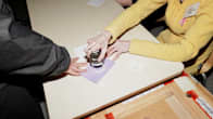 A poll worker stamping an election ballot.