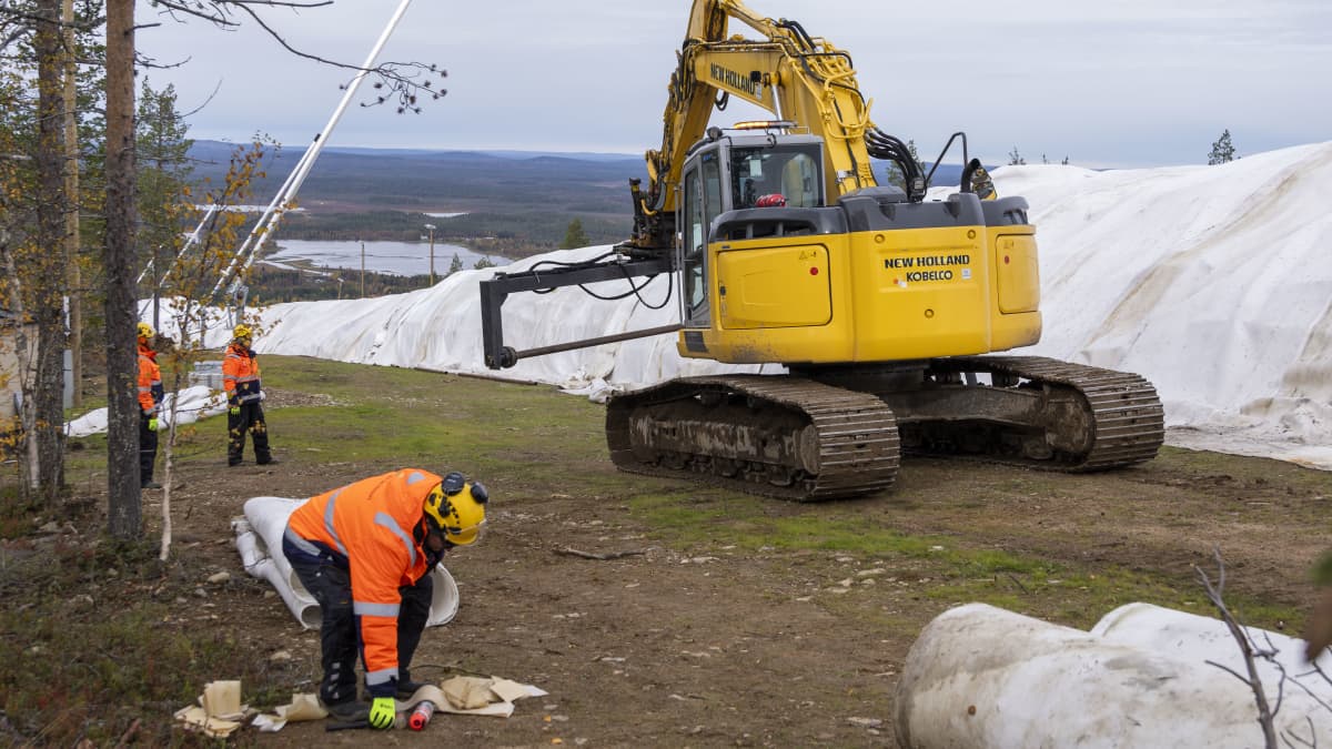 Työkone avaa eristehaitarimattoja Levirinteen päällä.