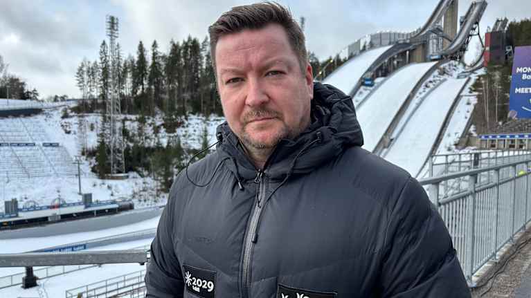 Image 2: Salpausselän kisojen toimitusjohtaja Tomi-Pekka Kolu Lahden Urheilukeskuksessa. Taustalla hyppyrimäet.