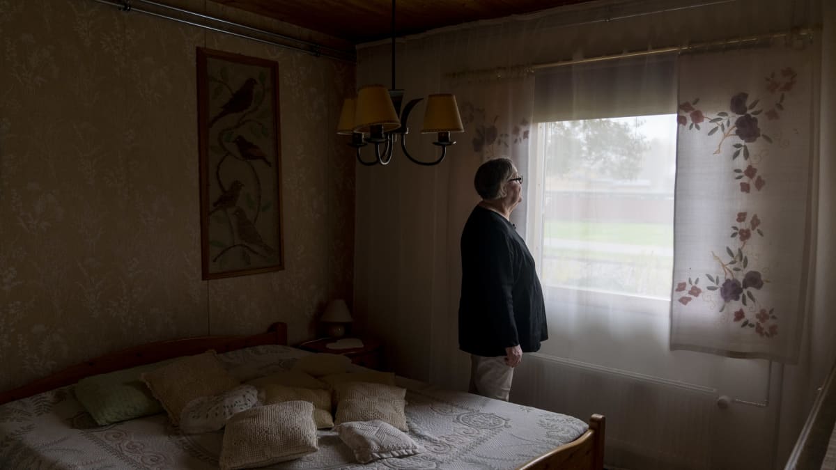 Anja Haaparanta seisoo makuuhuoneessaan ja katsoo ikkunan läpi tukiasemaa