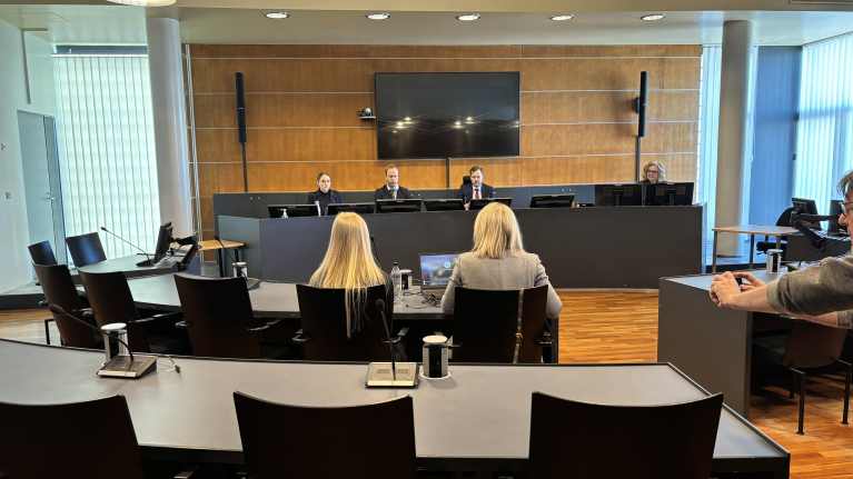 During a hearing in the District Court, the two women sat with their backs to the camera.