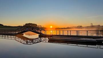 Aurinko nousee. Miltei tyyni Aurajoki, josta nousee usvaa.