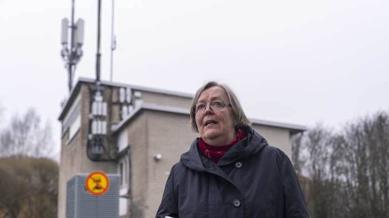 Anja Haaparanta seisoo pihallaan tukiaseman edessä