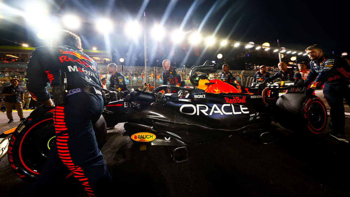 Red Bullin mekaanikot työntävät Max Verstappenin autoa.