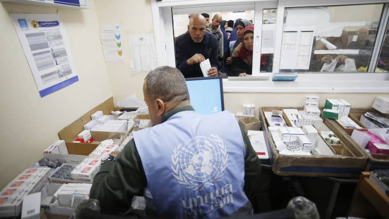 UNRWA:n työntekijä jakamassa lääkkeitä Deir Al-Balahissa Gazassa.