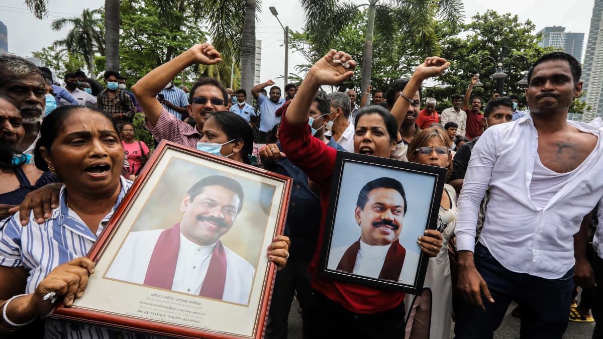 Mahinda Rajapaksan kannattajat pitelevät Rajapaksan muotokuvia mielenosoituksessa Colombossa