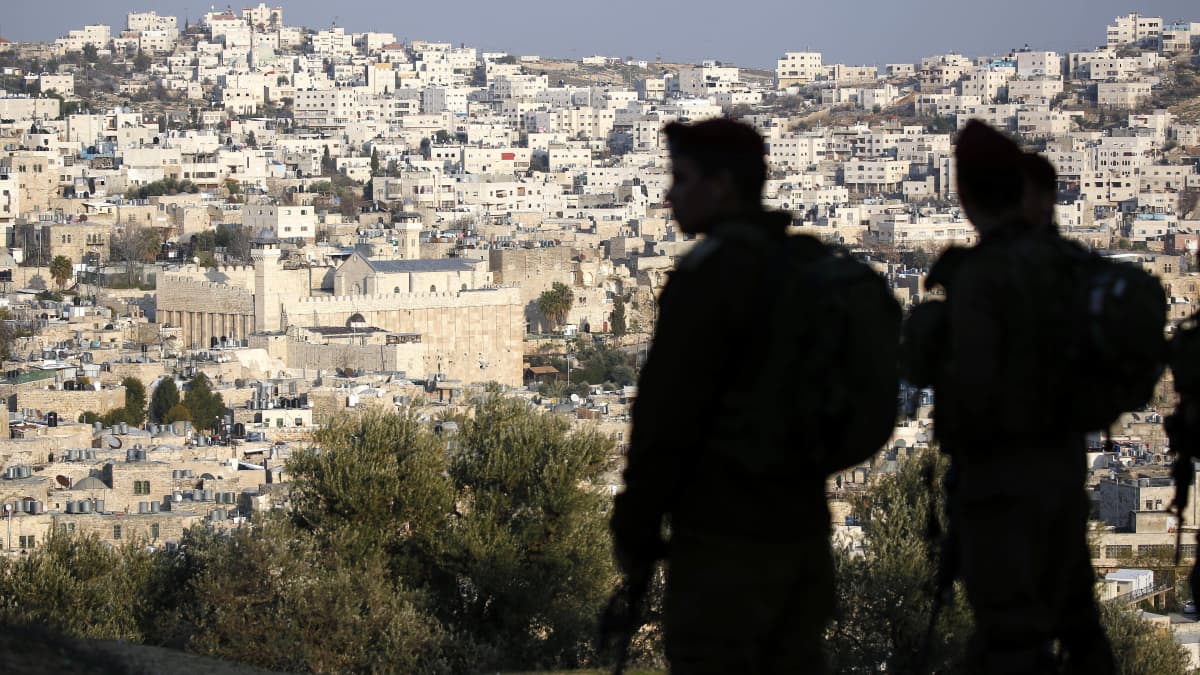 Kaksi israelilaissotilasta partioi. Taustalla näkyy Hebron ja Patriarkkojen hauta.