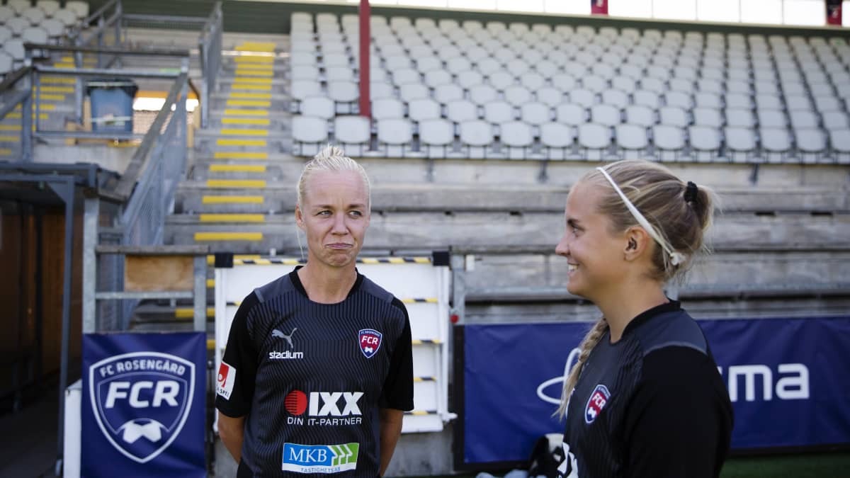 kaksi jalkapalloilijaa katsovat toisiaan ja nauravat