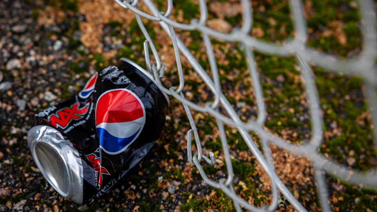 Pepsi-tölkki on maassa rutistettuna.
