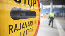 Rajavartiolaitoksen pysäytysmerkki ja rajavartija Niiralan rajanylityspaikalla.