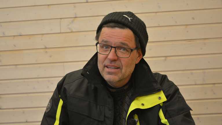 Anders Lång sitter i sitt kontor framför en vägg.