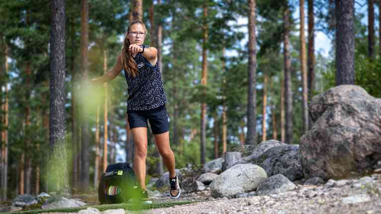 Frisbeegolfaaja Silva Saarinen katsoo heittämänsä kiekon perään Hausjärven frisbeegolfradalla.