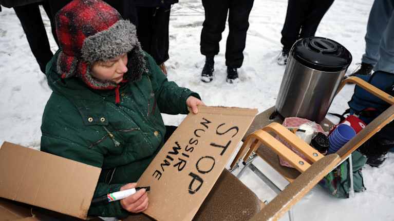 Mielenosoittaja kirjoittaa tekstiä pahvikylttiin.