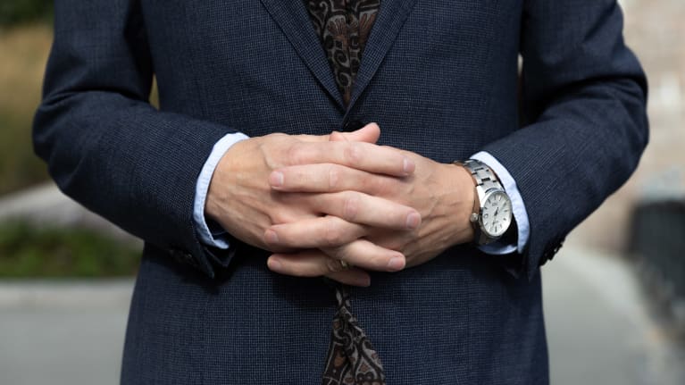 Miehen kädet ristissä vatsan päällä.