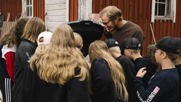 Luokanopettaja Janne Puolitaival esittelee koululaisille kompostin toimintaa.